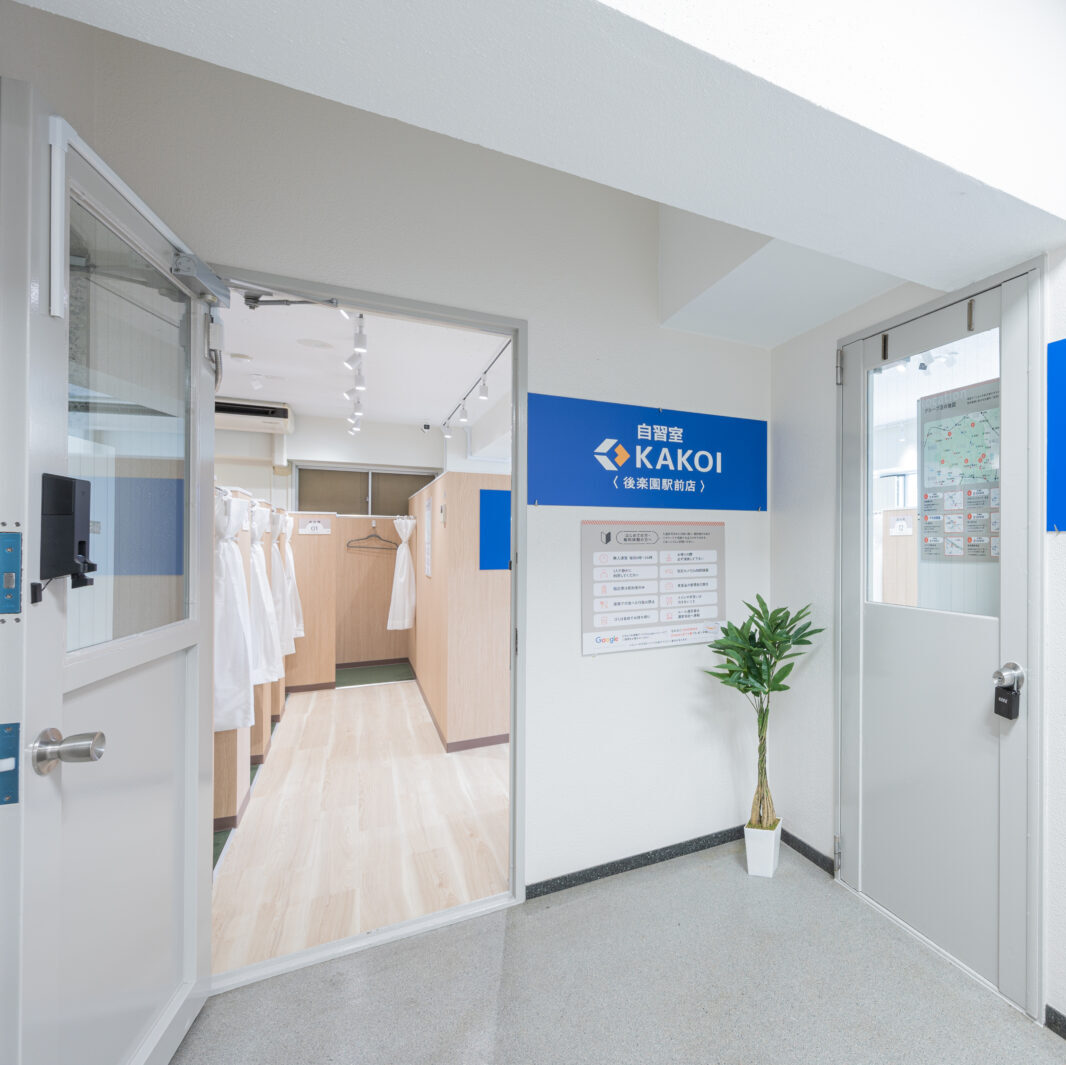 提案する代替テキスト:自習室KAKOI 後楽園駅前店のエントランス。扉の向こうにブースが見える